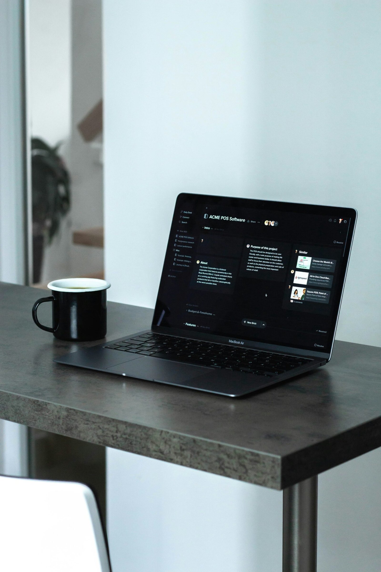 A laptop sitting on a desk with a mug next to it as a web designers setup